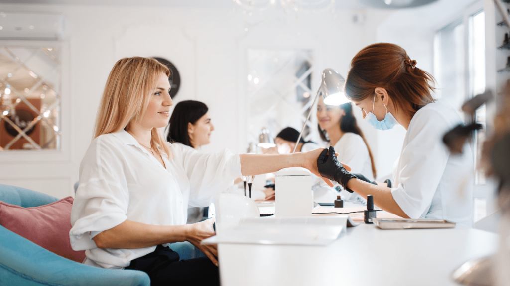 Мастер делает маникюр клиентке