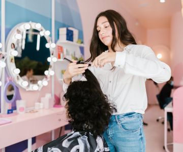 перукар робить укладку клієнту