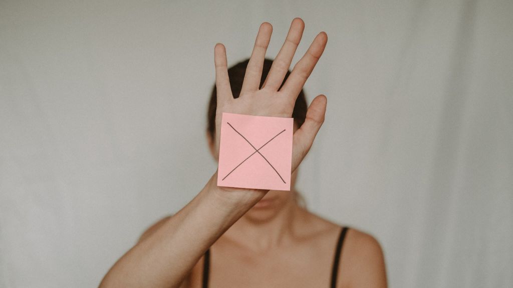 дівчина показує знак заборони