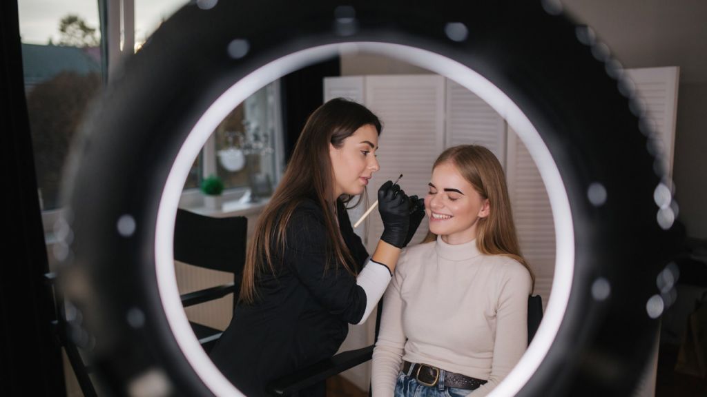 Бровист проводит процедуру окрашивания бровей