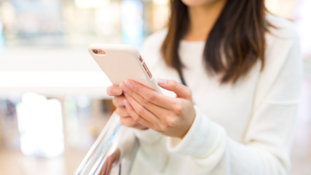 дівчина дивиться на екран смартфону