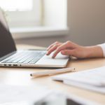 девушка проверяет отчетность за ноутбуком