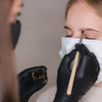 бровист красит брови клиентке