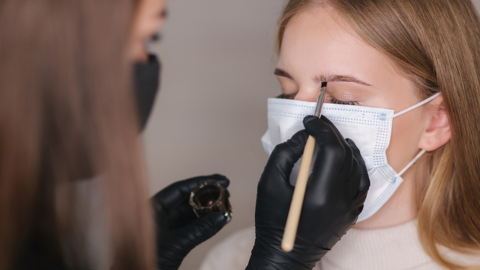 бровист красит брови клиентке